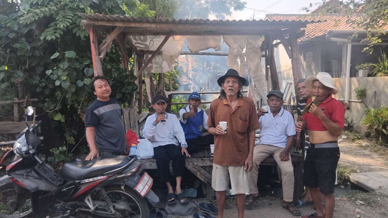 Warga istirahat setelah kerja bakti